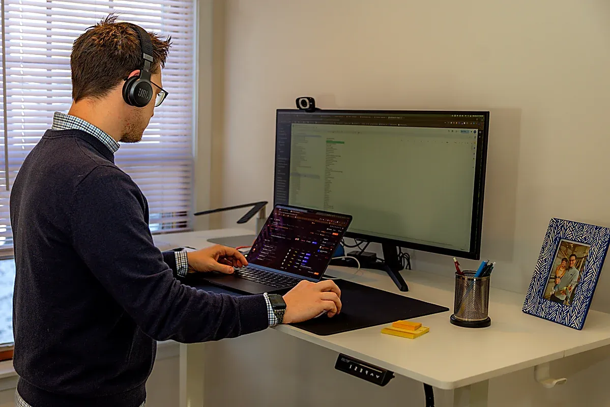 An Elevated Audience strategist at a standing desk, on a headset, working through a client's search and page data