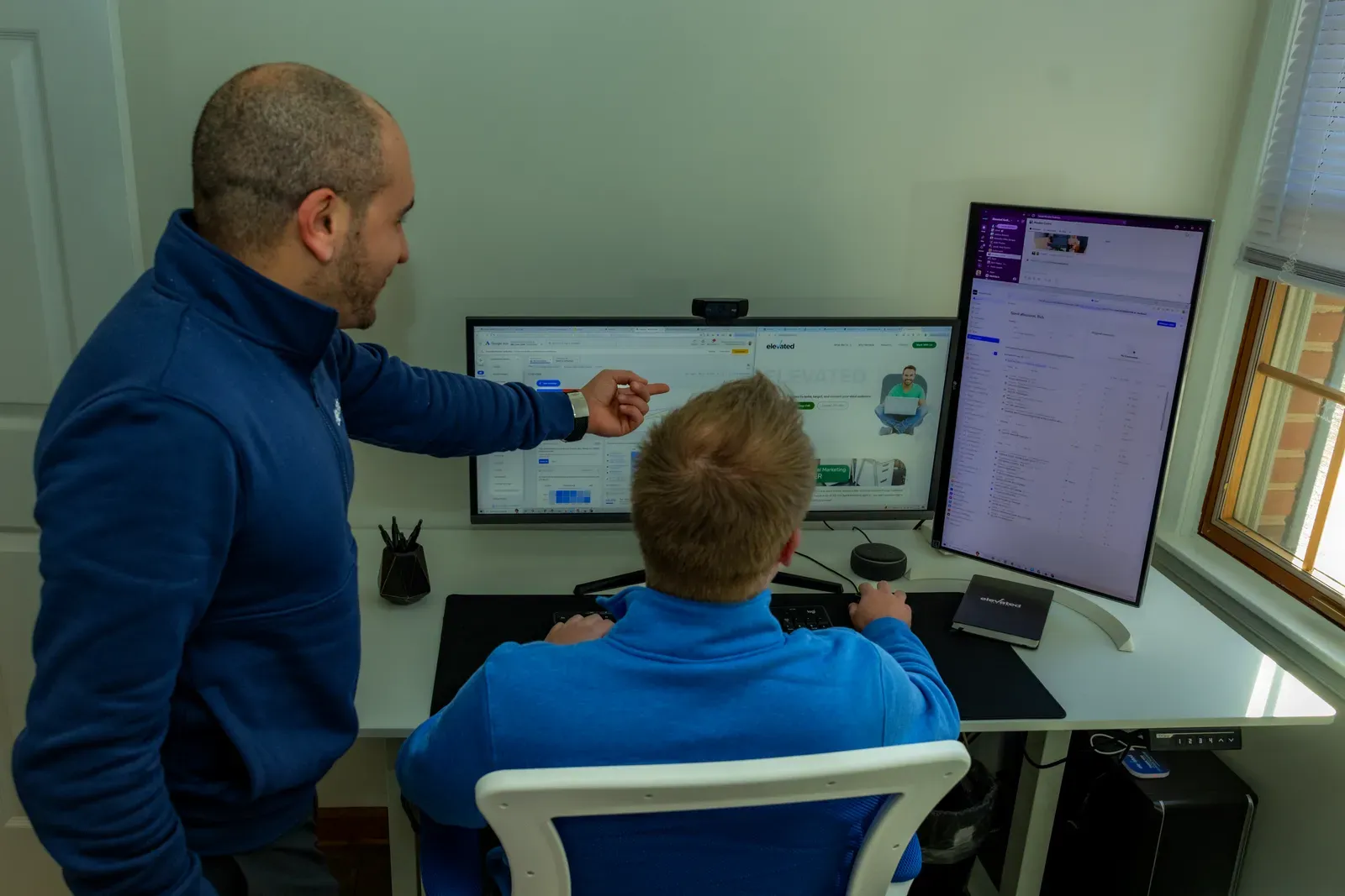 Two Elevated Audience team members reviewing a client account together